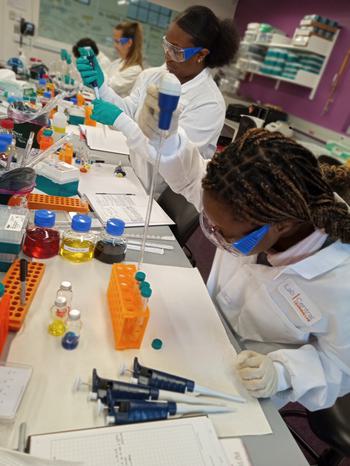 Photo of students in a lab using pipetting equipment