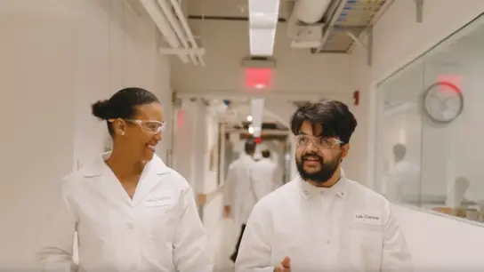 Two LabCentral resident scientists discussing their biotech research as they walk down the hallway to the lab